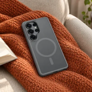 DUXDUCIS Phone Case for Samsung S26 Ultra with Magnetic - Grey Samsung S26 Ultra case on a rust-orange knitted throw over a beige reading chair beside an open book and a navy ceramic mug