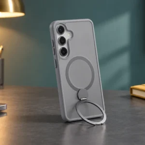 DUXDUCIS Phone Case for Samsung S25 with Stand - Grey Samsung S25 case supported in portrait orientation on a charcoal home-office desk beside a brass lamp and mustard-yellow notebook