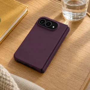 DUXDUCIS Phone Case for iPhone Ultra (iPhone Fold) - Dark Cherry Piel Series iPhone Ultra (iPhone Fold) case on a light oak lap desk over a cream armchair beside a mustard linen notebook and clear water glass