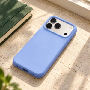 DUXDUCIS Phone Case for iPhone17 /18 Pro - Light Blue Piel Series iPhone 17 and 18 Pro case on an ivory limestone windowsill desk beside a forest green linen notebook and amber glass tumbler